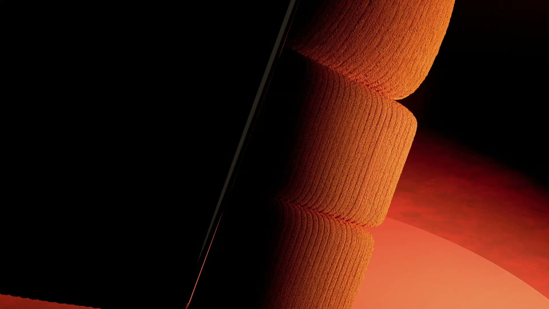 The TEDDY sofa in orange corduroy, turning slowly against a dark backdrop